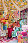 CHELSEA 2012 - KAFFE FASSETT SITS INSIDE  A SHED DECORATED BY HIM WITH NEEDLEPOINT DESIGNS