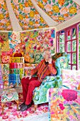 CHELSEA 2012 - KAFFE FASSETT SITS INSIDE  A SHED DECORATED BY HIM WITH NEEDLEPOINT DESIGNS