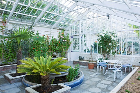 GRANGE_COURT__GUERNSEY_FOUNTAIN_IN_THE_RESTORED_GLASSHOUSE_WITH_TABLE_AND_CHAIRS