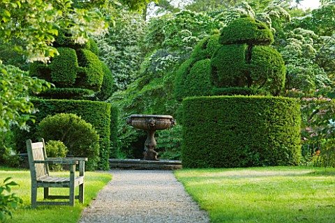 NYMANS__SUSSEX_THE_NATIONAL_TRUST__GRAVEL_PATH_WITH_WOODEN_BENCH___TOPIARY_YEW_AND_ITALIAN_MARBLE_FO