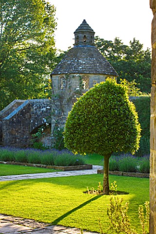 NYMANS__SUSSEX_THE_NATIONAL_TRUST_THE_FORECOURT_IN_EVENING_LIGHT_WITH_STONE_PATHS__DOVECOTE_AND_STAN