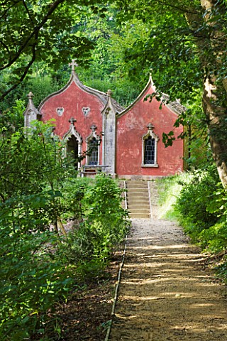 PAINSWICK_ROCOCO_GARDEN__GLOUCESTERSHIRE_THE_RED_HOUSE_SEEN_ALONG_A_WOODLAND_PATH