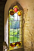 PAINSWICK ROCOCO GARDEN  GLOUCESTERSHIRE: STAINED GLASS IN A WINDOW IN THE RED HOUSE