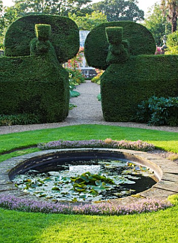 PECKOVER_HOUSE__WISBECH__CAMBRIDGESHIRE_THE_NATIONAL_TRUST__CIRCULAR_POOL_AND_TOPIARY_PEACOCKS_IN_TH