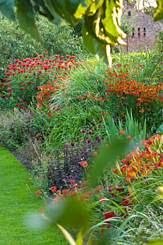 PECKOVER_HOUSE__WISBECH__CAMBRIDGESHIRE_THE_NATIONAL_TRUST__RED_BORDER_WITH_HELENIUMS__HEMEROCALLIS_