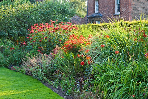 PECKOVER_HOUSE__WISBECH__CAMBRIDGESHIRE_THE_NATIONAL_TRUST__RED_BORDER_WITH_HELENIUMS__MONARDAS_AND_