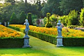 THE NATIONAL TRUST: CLIVEDEN  BUCKINGHAMSHIRE: TOPIARY  STATUARY AND BOX EDGED BEDS PLANTED WITH RUDBECKIA  IN THE LONG GARDEN  EVENING LIGHT