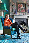 VELVET ECCENTRIC: RACHEL BERGER SITS IN A VELVET BLUE CHAIR BY VELVET ECCENTRIC IN THE DRAWING ROOM
