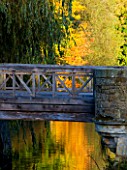 HEVER CASTLE  KENT  AUTUMN: BRIDGE OVER THE MOAT IN AUTUMN WITH REFLECTIONS OF TREES