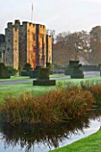HEVER CASTLE  KENT  AUTUMN: VIEW TO THE CASTLE ACROSS THE MOAT WITH TOPIARY IN FOREGROUND