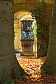 HEVER CASTLE  KENT: AUTUMN: VIEW FROM OUTSIDE THE ITALIAN GARDEN THROUGH TREES TO HUGE URN/ CONTAINER IN THE ITALIAN GARDENS