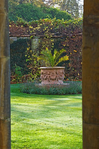 HEVER_CASTLE__KENT_AUTUMN_VIEW_THROUGH_COLUMNS_IN_THE_LOGGIA_TO_PALM_IN_LARGE_TERRACOTTA_CONTAINER_O