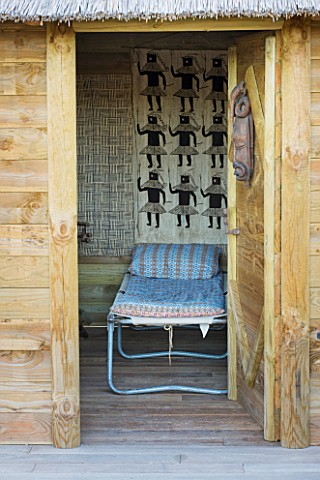 AFRICAN_GARDEN__PROVENCE__FRANCE_DESIGNER_DOMINIQUE_LAFOURCADE_CAMP_BED_IN_THE_THATCHED_HUT