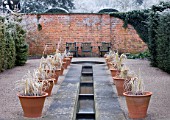 HAMPTON COURT CASTLE AND GARDENS  HEREFORDSHIRE: RILL IN WALLED GARDEN WITH TERRACOTTA CONTAINERS AND WOODEN CHAIRS