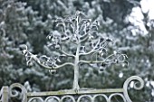 HAMPTON COURT CASTLE AND GARDENS  HEREFORDSHIRE: ORNATE METAL PEAR TREE ON TOP OF GATE IN WALLED GARDEN IN FROST