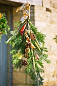 THE GARDEN AND PLANT COMPANY  HATHEROP  GLOUCESTERSHIRE: FESTIVE HAND-TIE WITH PINE  PINE CONES  CINNAMON  CHILLIES AND DRIED ORANGE SLICES