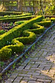 DIAL PARK  WORCESTERSHIRE: BOX TOPIARY (BUXUS) IN THE SHAPE OF A SNAKE BESIDE PATH