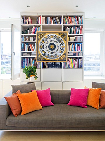 SHELLEY_VON_STRUNCKEL_APARTMENT__LONDON_MOCHA__COLOURED_SOFA_WITH_ORANGE_AND_PINK_CUSHIONS_WITH_BOOK