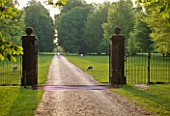 DODDINGTON PLACE GARDENS  KENT: VIEW THROUGH THE GATE TO THE PARK WITH SHEEP BEYOND