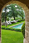 LA CARMEJANE, FRANCE: LUBERON, PROVENCE, FRENCH, COUNTRY, GARDEN, TERRACE, PATIO, GRASS, LAWN, SUMMER, CLIPPED, TOPIARY, BOX, BALLS, SWIMMING, POOLS, FRAME, FRAMING, ARCHWAY