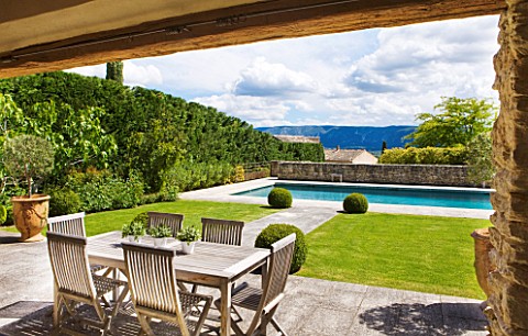 GARDEN_IN_LUBERON__FRANCE__DESIGNED_BY_MICHEL_SEMINI_VIEW_OUT_OF_POOL_HOUSE_TO_LAWN_AND_PATH_TO_SWIM