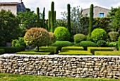 GARDEN IN LUBERON  FRANCE  DESIGNED BY MICHEL SEMINI: STONE WALL  CLIPPED TOPIARY AND CYPRESS TREES IN A FORMAL GARDEN - WASSERMAN GARDEN