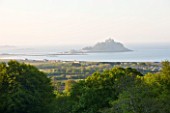 TREMENHEERE SCULPTURE GARDENS  CORNWALL: VIEW OF ST MICHAELS MOUNT FROM THE GARDEN AT DAWN