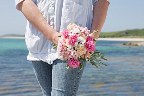 THE_ISLES_OF_SCILLY_SCILLY_FLOWERS__FRESHLY_PICKED_SCENTED_PINKS_BY_SEA__HELD_BY_STEPH_HILL