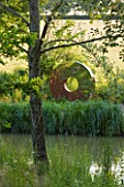 GARDEN IN KENT DESIGNED BY BELLA WHITELEY: THE PORTAL SCULPTURE BY DAVID HARBER BESIDE THE POOL, POND, LAKE. ORNAMENT, REFLECTION, REFLECTED, REFLECTIONS