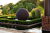 GARDEN IN KENT DESIGNED BY BELLA WHITELEY: CANAL, RILL, DARK PLANET SCULPTURE BY DAVID HARBER. PATIO, TERRACE, SUMMER