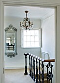 RICHARD CARNILL HOUSE  NOTTINGHAMSHIRE: SECOND FLOOR LANDING WITH VENETIAN MIRROR FROM CARNILL & COMPANY. VINTAGE CHANDELIER FROM CRYSTAL CORNER. RECLAIMED IRON GARDEN BALUSTRADES