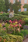 KILLERTON  DEVON: THE NATIONAL TRUST - HERBACEOUS GARDEN WITH DIERAMA  ALLIUMS  PENSTEMON AND ROSES WITH COADE STONE URN AND WEST FRONT OF HOUSE BEHIND