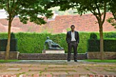 GLYNDEBOURNE, EAST SUSSEX: THE FIGARO GARDEN WITH LAWN AND PAVING AND BRONZE BY SEAN HENRY - STANDING MAN - IN FRONT OF HENRY MOORE STATUE - MIST, FOG, SCULPTURE