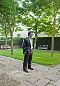 GLYNDEBOURNE, EAST SUSSEX: THE FIGARO GARDEN WITH LAWN AND PAVING AND BRONZE BY SEAN HENRY - STANDING MAN - MIST, FOG, SCULPTURE