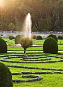 CHATEAU DE CHENONCEAU  FRANCE: FOUNTAIN AND SWIRLS OF SANTOLINA IN DIANES GARDEN  MORNING LIGHT