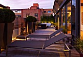 ROOF GARDEN IN SHOREDITCH  LONDON  DESIGNED BY AMIR SCHLEZINGER OF MY LANDSCAPES: DECKING  BUDDHA STATUE  DECK CHAIRS  BOX BALLS IN CONTAINERS  LIT UP AT NIGHT  LIGHTING
