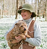 WELFORD PARK, BERKSHIRE: DEBORAH PUXLEY WITH HER PET DOG IN THE SNOWDROP WOOD IN FEBRUARY - WOMAN, LADY, WINTER