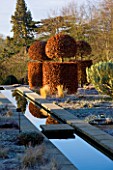 BROUGHTON GRANGE, OXFORDSHIRE: DESIGNER TOM STUART - SMITH: CLIPPED TOPIARY BEECH HEDGES IN FROST IN THE WALLED GARDEN. WINTER, COUNTRY GARDEN, STEPPING STONE, RILL, WATER, CANAL