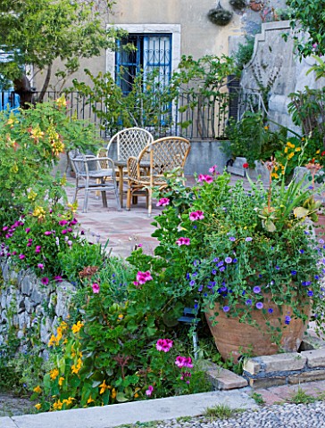 SICILY__ITALY_CASA_CUSENI_IN_TAORMINA__TERRACOTTA_TERRACE__PATIO_WITH_WRATTEN_CHAIRS_AND_TERRACOTTA_