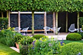 CHELSEA FLOWER SHOW 2014: TELEGRAPH GARDEN -  ITALIAN GARDEN BY DEL BUONO GAZERWITZ - CHAIRS ON TERRACE WITH TRAINED LIME TREES - TILIA X EUROPAEA PALLIDA AND CLIPPED BOX