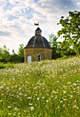 ROCKCLIFFE HOUSE  GLOUCESTERSHIRE: THE MEADOW WITH OXE-EYE DAISIES WITH DOVECOT