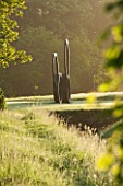 ROCKCLIFFE HOUSE, GLOUCESTERSHIRE: HA HA AT DAWN WITH LAWN AND BRONZE SCULPTURE SOUTHERN SHADE BY NIGEL HALL - DAWN, COUNTRY GARDEN, ORNAMENT