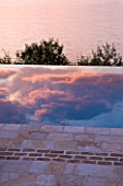 CORFU, GREECE - THE KASSIOPIA ESTATE: THE SWIMMING POOL WITH EVENING CLOUDS REFLECTED IN IT