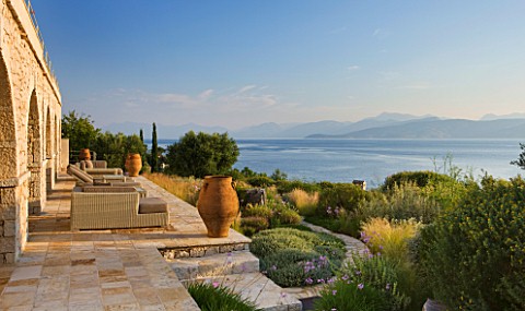 CORFU_GREECE__THE_KASSIOPIA_ESTATE_THE_STONE_TERRACE_WITH_SEATING_AREA_GARDEN_TERRACOTTA_URNS_AND_VI