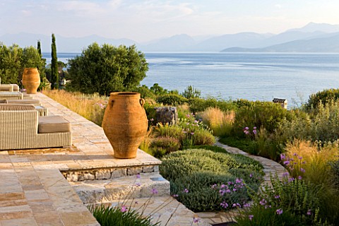 CORFU_GREECE__THE_KASSIOPIA_ESTATE_THE_STONE_TERRACE_WITH_SEATING_AREA_GARDEN_TERRACOTTA_URNS_AND_VI