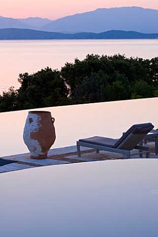 CORFU_GREECE__THE_KASSIOPIA_ESTATE_VIEW_OF_POOL_TERRACE_LOOKING_OUT_TO_SEA_AT_DUSK_WITH_TERRACOTTA_U