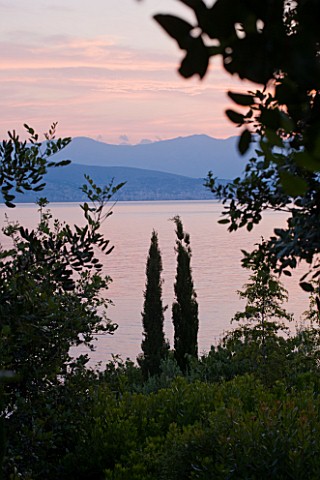 CORFU_GREECE__THE_KASSIOPIA_ESTATE_VIEW_OUT_TO_SEA_AT_SUNSET_WITH_CYPRESS_AND_OLIVE_TREES_WITH_ALBAN