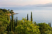 CORFU, GREECE - THE KASSIOPIA ESTATE. VIEW OUT TO SEA WITH ALBANIAN MOUNTAINS IN THE DISTANCE WITH OLIVE AND CYPRESS TREES. MEDITERRANEAN.