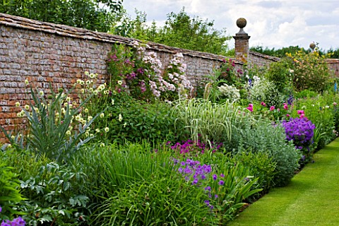 BIRTSMORTON_COURT_WORCESTERSHIRE_THE_WALLED_GARDEN__BORDER_WITH_PEONIES_TRADESCANTIA_CLEMATIS_ROSES_