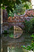 BIRTSMORTON COURT, WORCESTERSHIRE: VIEW OF STONE AND BRICK BRIDGE OVER THE MOAT IN SUMMER. WATER, LAKE